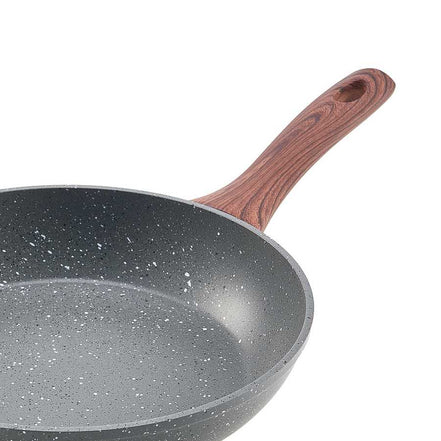 Detail of ergonomic wood-style handle on nonstick frying pan from 3 piece aluminum skillet set.