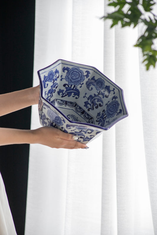 Blue and White Decorative Bowl - Porcelain, Elegant Design held by hands near a white curtain, showcasing its floral interior pattern.