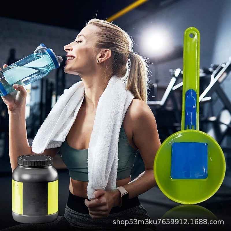 A woman in a gym setting drinks from a blue water bottle while wearing a white towel around her neck. A large green and blue cleaning brush is shown prominently on the right, and a black supplement tub with yellow labels appears at the bottom left.