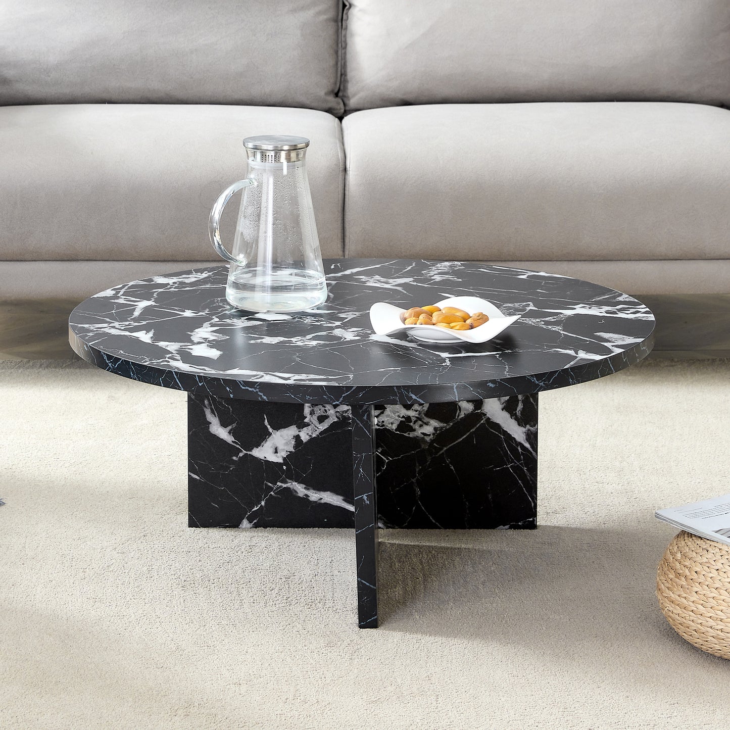 Contemporary black MDF round coffee table with faux marble top, placed in a cozy living room setting with neutral decor.