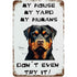 Metal sign with a Rottweiler graphic and text about house rules.