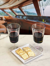 Two LeadingWare BPA-free plastic wine glasses with red wine beside crackers, perfect for boating or outdoor dining.