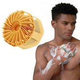 Man using a yellow scrubber on his arm with a close-up of the scrubber on a white background.