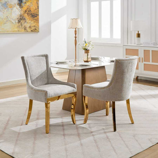 Dining room with a table and two gray chairs in a well-lit room.