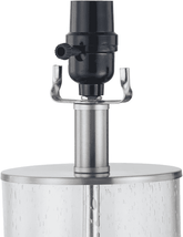 Close-up of a sprinkler head assembly with a black spray nozzle, curved metal sprinkler arm, and a cylindrical clear plastic or glass riser tube on a white background.