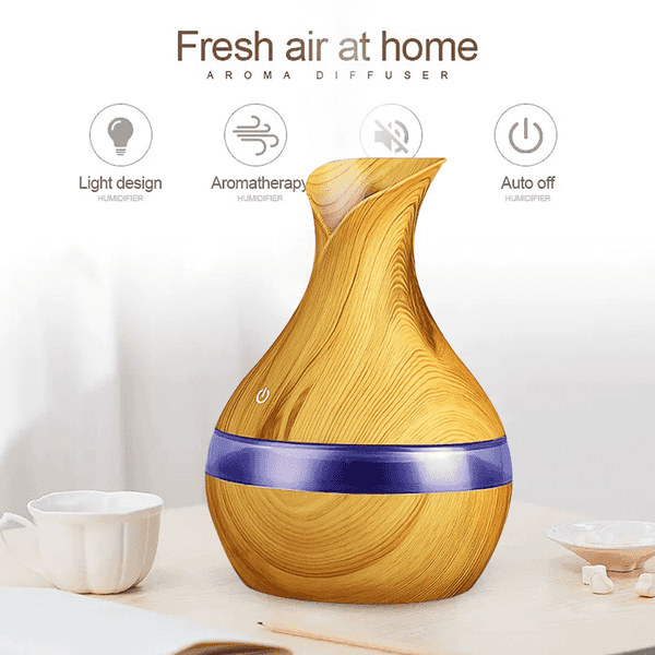Wood grain aroma diffuser with a purple band, shown on a tabletop with small cups and text overlays highlighting features like light design, aromatherapy, silent operation, and auto off.