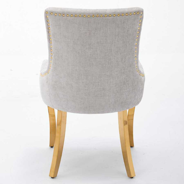 Gray upholstered chair with gold nailhead trim on a white background