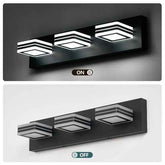 A three-light wall-mounted fixture shown in two states: illuminated at the top and unlit at the bottom. The fixture has a matte black rectangular body with three square shades featuring black-and-white striped geometric patterns.