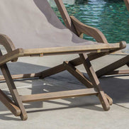 Wooden lounge chair with a gray cushion by a poolside