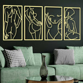 Four gold line art panels on a black wall above a green sofa with decorative pillows.