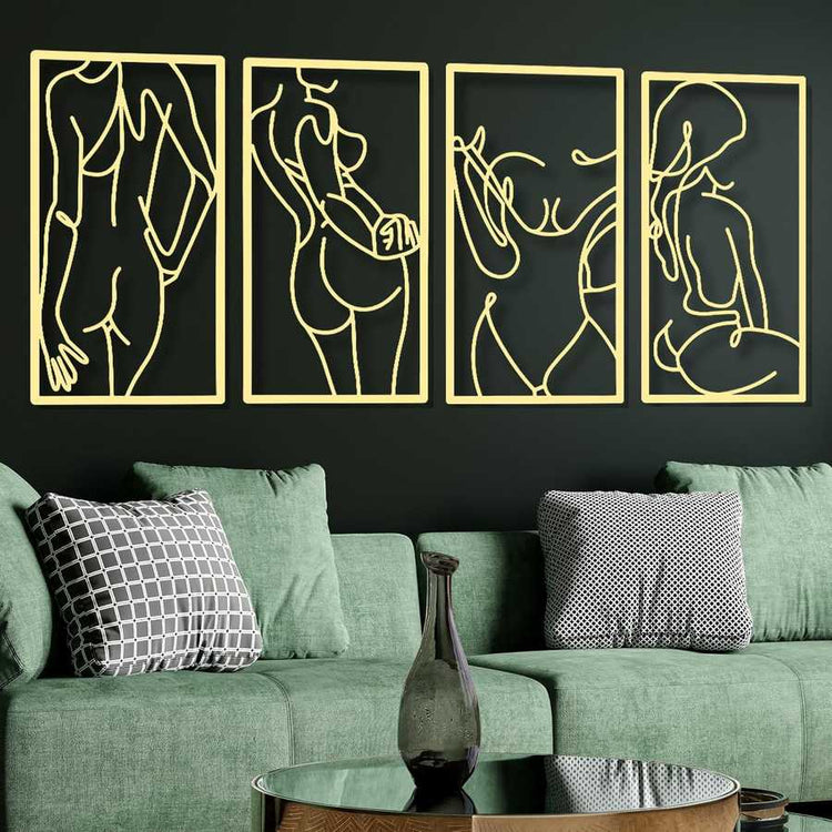 Four gold line art panels on a black wall above a green sofa with decorative pillows.