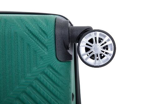 Close-up of a green hardshell suitcase with a textured geometric pattern and a black-and-silver spinner wheel on a white background.