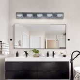 Bathroom vanity with mirror, lights, and various items on a neutral wall.