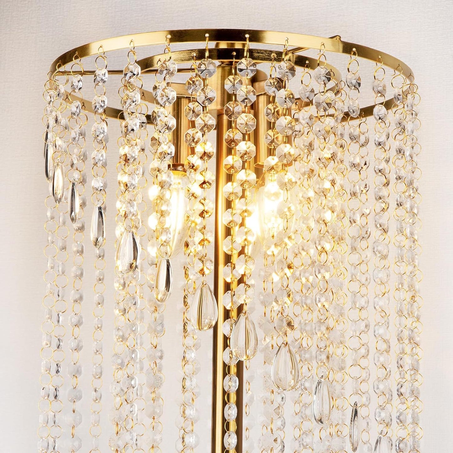 Close-up of gold floor lamp for living room featuring sparkling crystal strands and dual LED bulbs for a luxurious lighting effect.