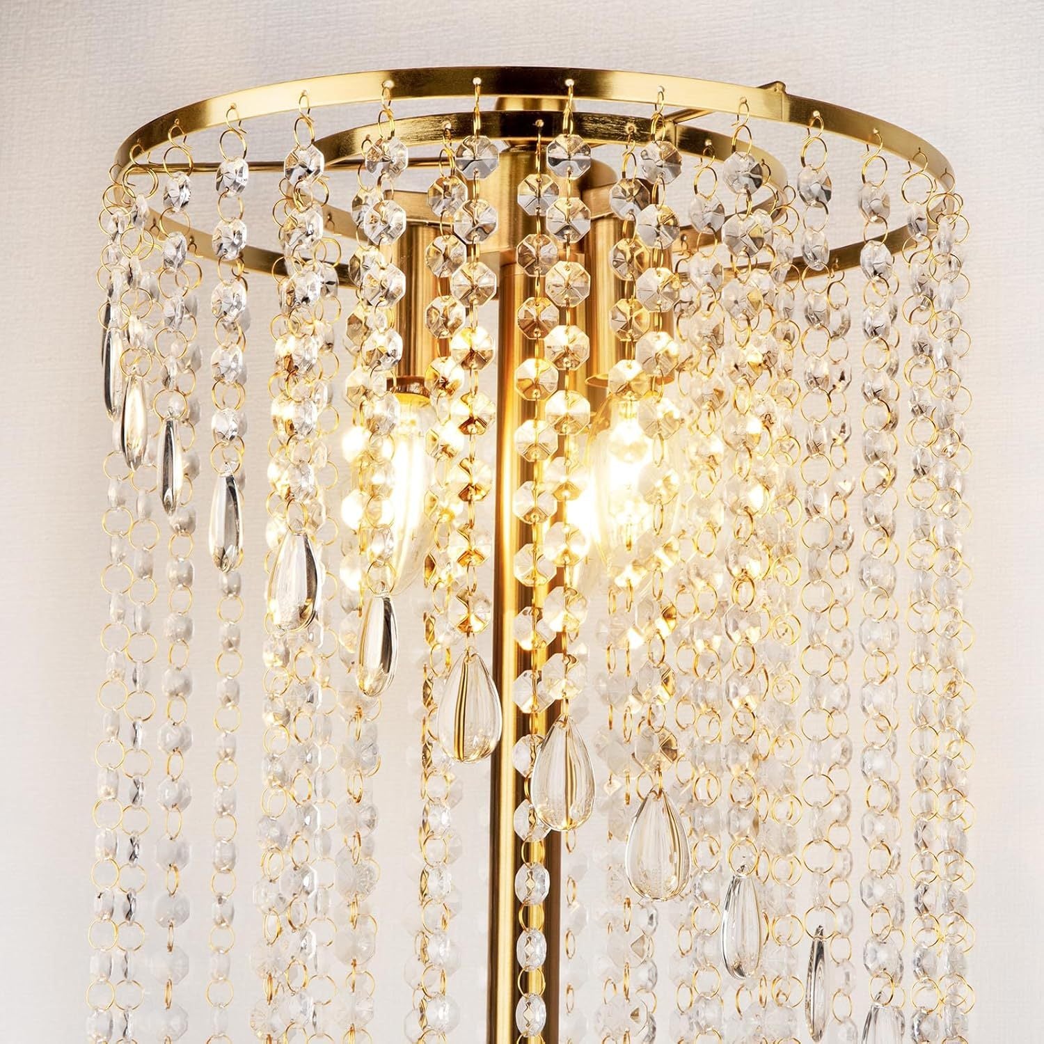Close-up of gold floor lamp for living room featuring sparkling crystal strands and dual LED bulbs for a luxurious lighting effect.