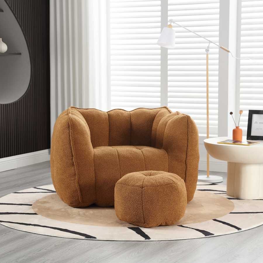 Brown armchair and ottoman on a rug in a modern room with a lamp and table.