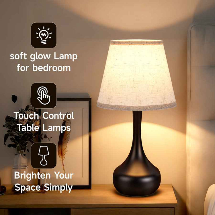 Table lamp with soft glow on a bedside table, featuring touch control.