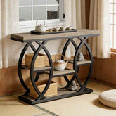 A rustic console table with a weathered wood top and shelves, supported by a black metal frame with interlocking circular arches. The table is styled in a Japanese-inspired room with a teapot, cups, baskets, and small figurines on and around it.