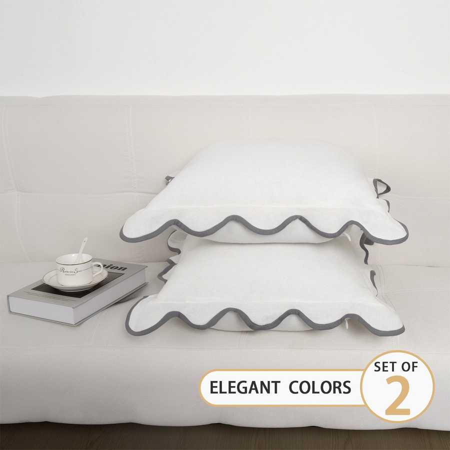 Set of two decorative pillows with ruffled edges on a bed, labeled &