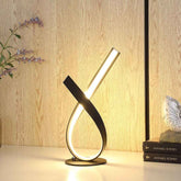 Modern table lamp with a unique design on a wooden surface.