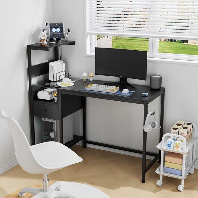 Computer desk with power outlet and USB ports in black, set up in a bright home office with reversible shelves and compact design.