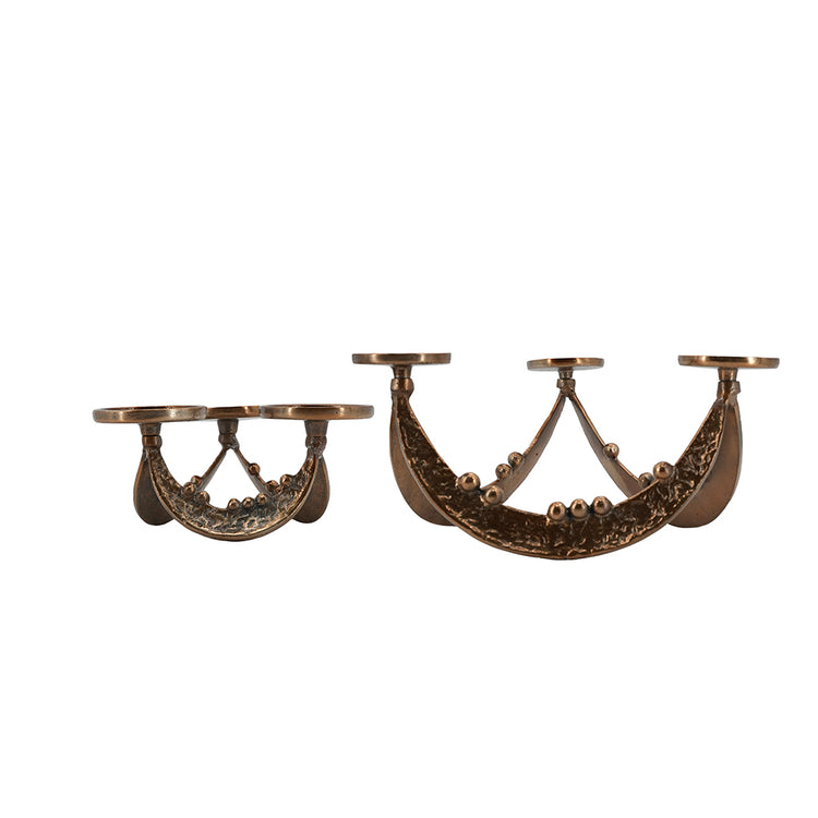 A pair of ornate bronze wall-mounted candle holders with decorative scrollwork and three candle cups each, shown against a plain white background.