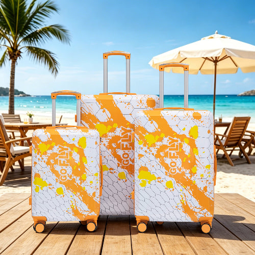 Two suitcases with orange and white design on a beach setting