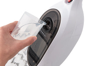 A close-up of a white handheld steam cleaner with a person&