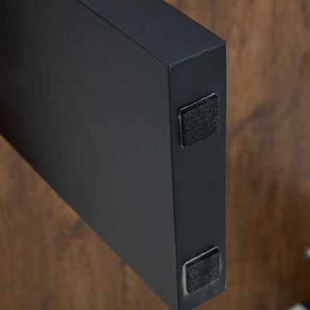 Bottom of black leg on Modern Minimalist Walnut MDF Coffee Table with felt pads for floor protection and stability.