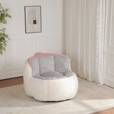 White and gray bean bag chair with pink blanket in a room with white walls and curtains.