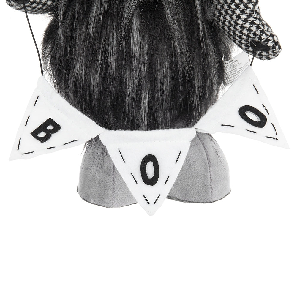 Person wearing a black and white checkered hat with a decorative headband featuring &