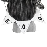 Person wearing a black and white checkered hat with a decorative headband featuring &