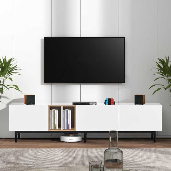 Modern TV stand for 80 inch TV in white with wood accents, featuring drop-down doors and open shelving for media storage.