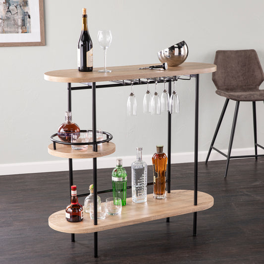 Dagney Wine Bar Table Storage in natural and black finish with glassware rack, three-tier shelving, and modern design for home bar setup.