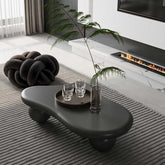 40 Inch Black Cloud Coffee Table with round legs in front of a fireplace, blending modern design and functionality for elegant interiors.