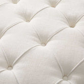 Close-up of a white tufted cushion with a soft texture