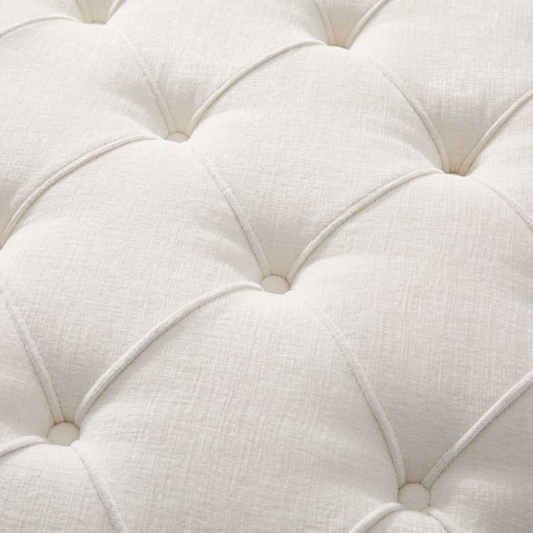 Close-up of a white tufted cushion with a soft texture