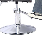 Foot on chrome footrest of Heavy Duty Barber Chair, demonstrating comfort and support during salon services.