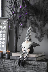 Halloween-themed decor with a ghostly figure, books, and candles on a dark background.