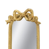 Gold ornate mirror frame featuring a sculpted bow at the top, shown against a plain white background.