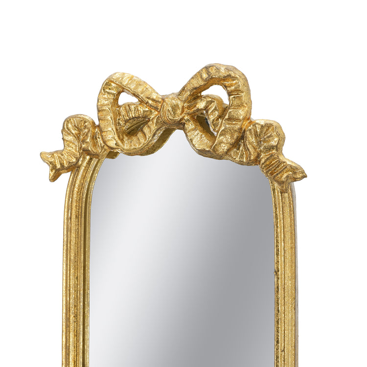 Gold ornate mirror frame featuring a sculpted bow at the top, shown against a plain white background.