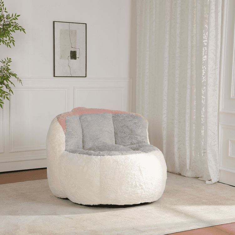 White and gray bean bag chair with pink interior in a room with white walls and curtains.