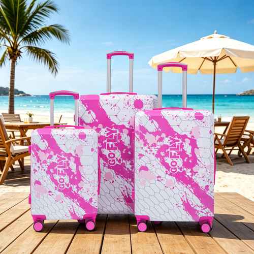 Pink printed spinner luggage suitcases on beachside wooden deck with umbrellas, featuring 20, 24, and 28-inch sizes, perfect for vacation.