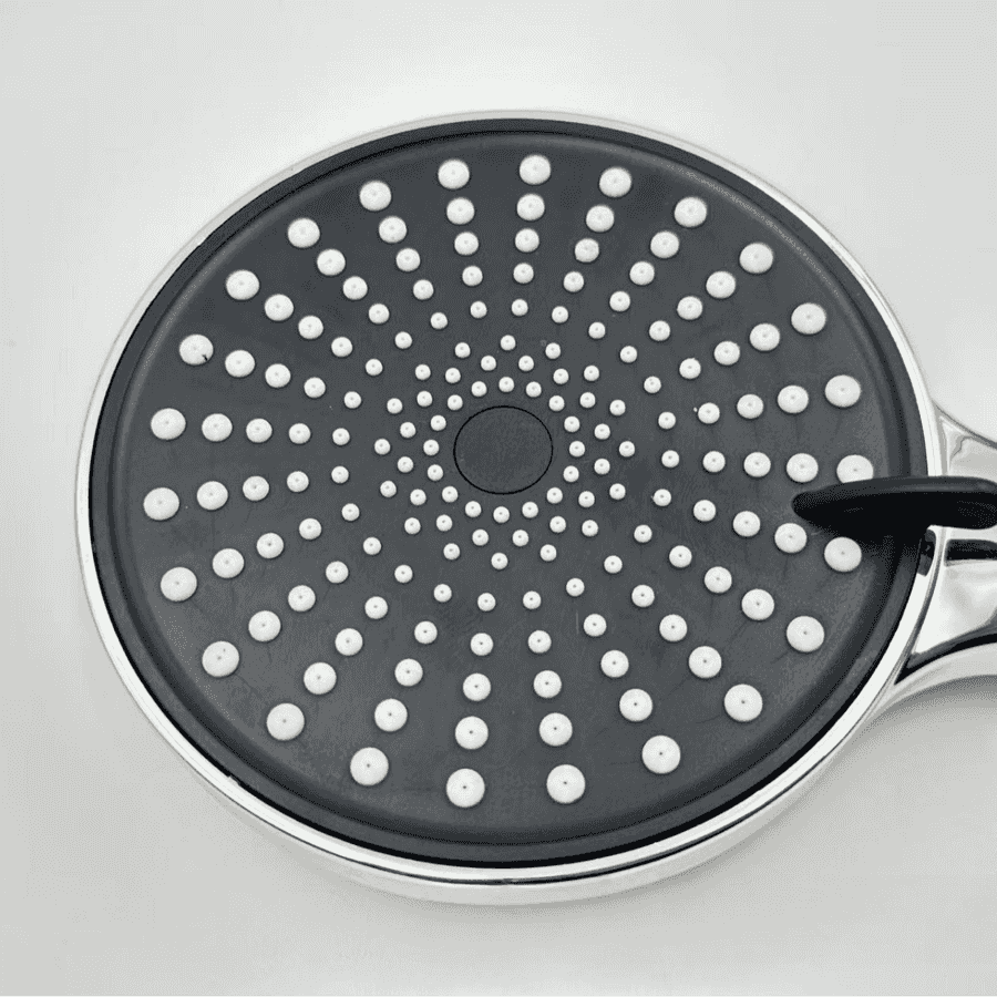 Black frying pan with white dot pattern on a light gray background