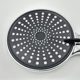 Black frying pan with white dot pattern on a light gray background