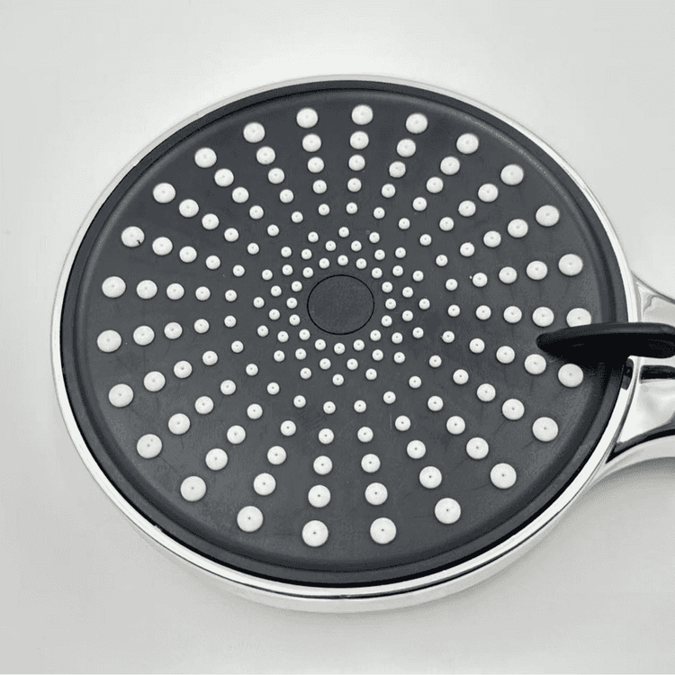 Black frying pan with white dot pattern on a light gray background