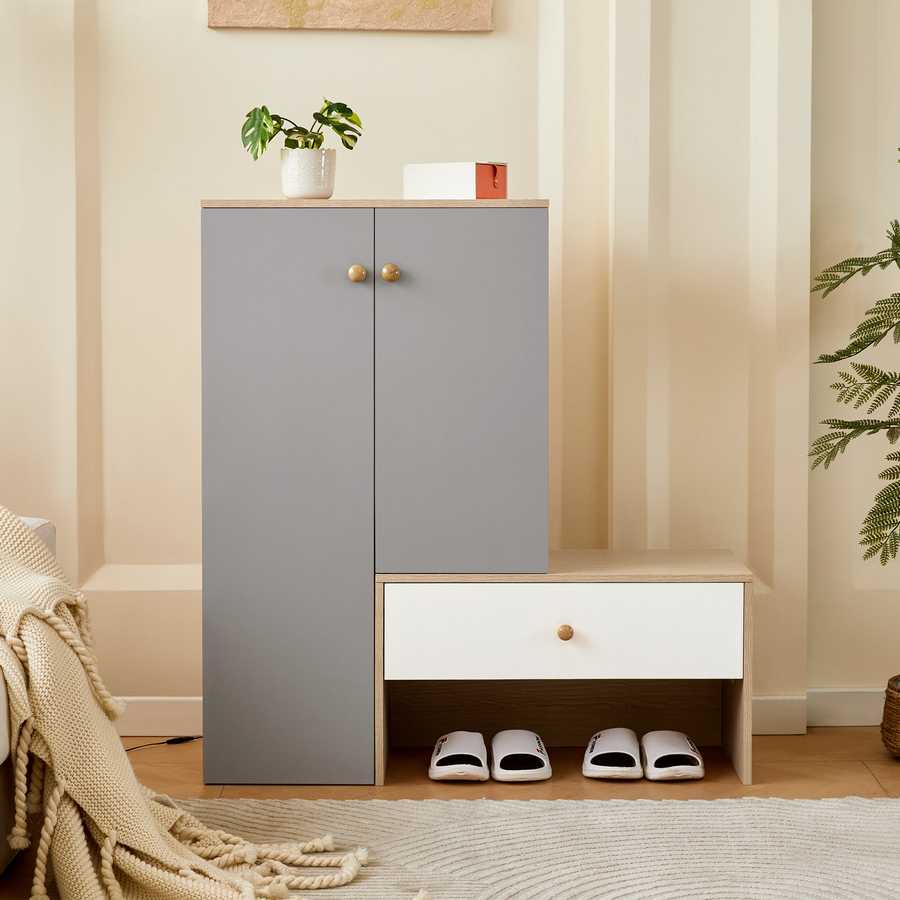 Modern shoe storage bench & cabinets in a styled entryway with slippers stored underneath and decorative items on top.