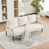 Beige sofa with a white blanket on a patterned rug in a living room setting.