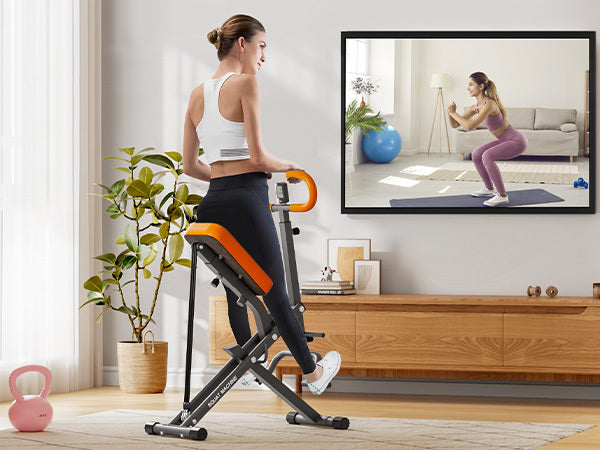 User performing squats on Squat Rowing Machine at home while following a virtual workout, ideal for full body fitness in small spaces.