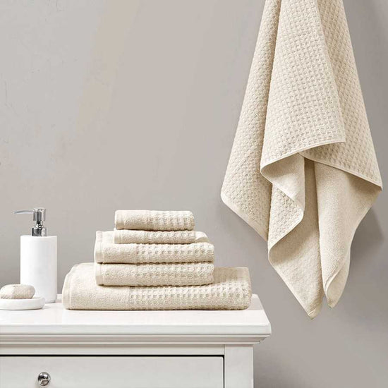 Antimicrobial cotton waffle bath towel set in ivory displayed on a white vanity, includes 2 bath, 2 hand, and 2 wash towels.